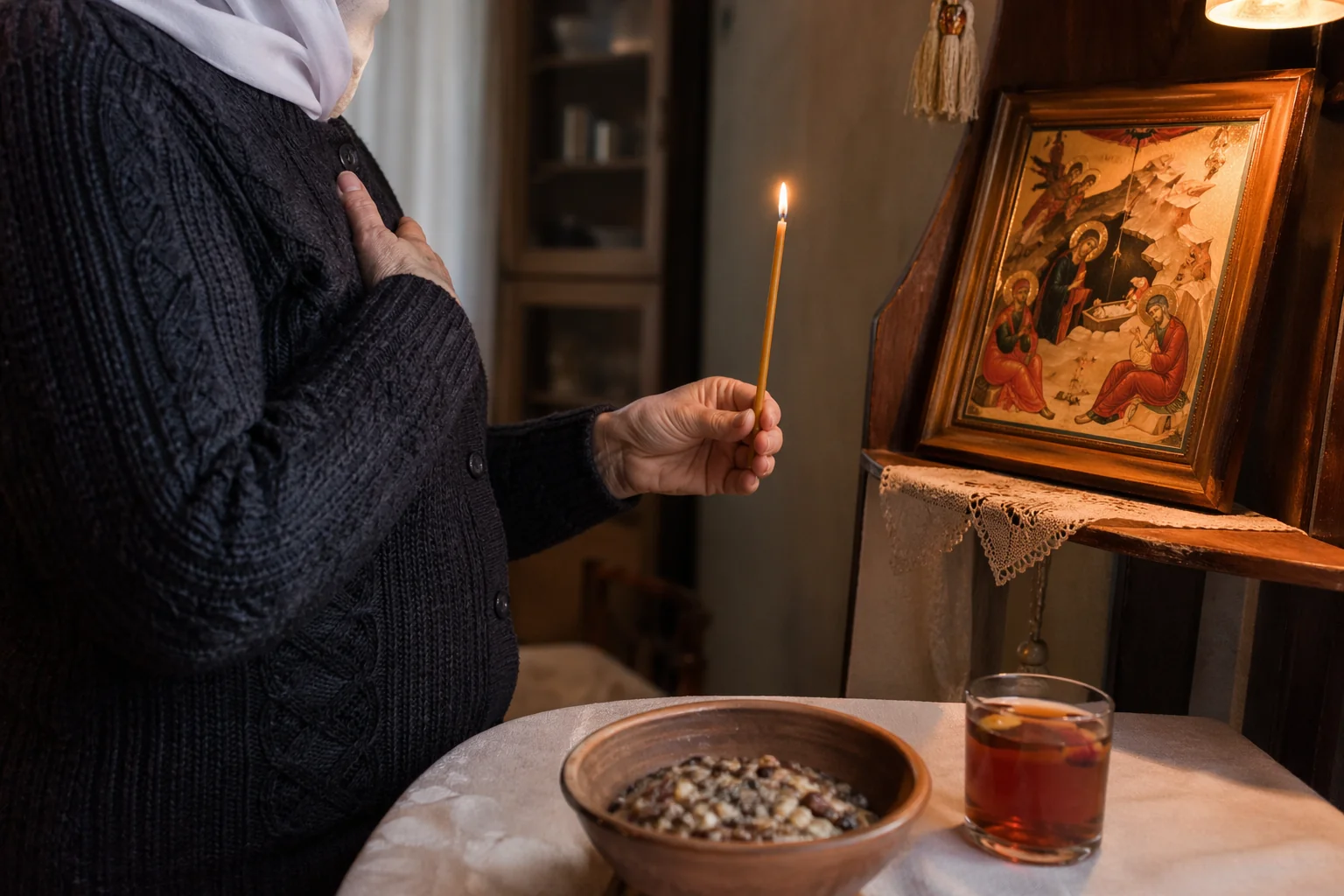 Руки пожилой женщины держат тонкую церковную свечу перед иконой Рождества Христова — чтение рождественского оберега для всей семьи