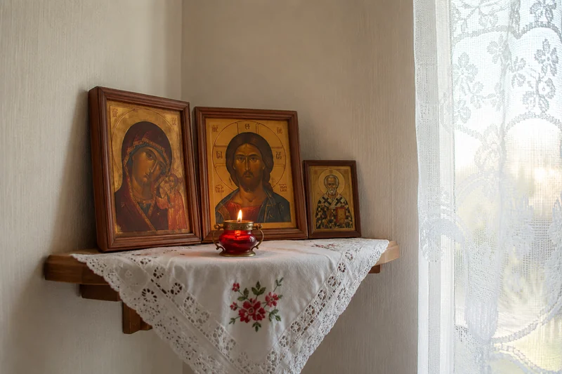Икона Богородицы и зажжённая лампада в красном углу домашней божницы, тёплый утренний свет из окна — как молиться матери о детях