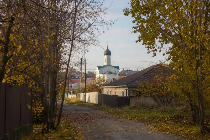 Небольшой православный храм в мягком утреннем свете ранней осени, тропинка среди пожелтевших деревьев — Рождество Пресвятой Богородицы 21 сентября