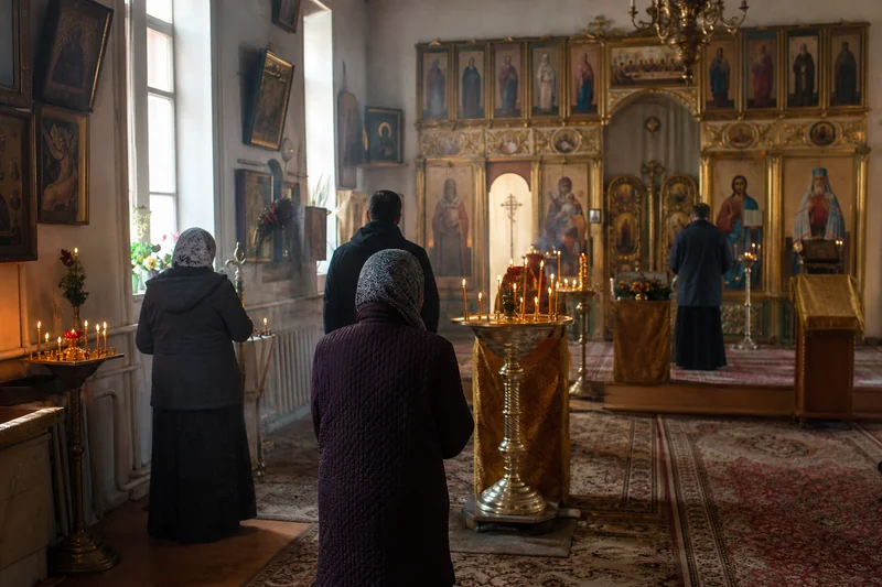 Прихожане в полумраке храма на утренней службе Воздвижения Креста Господня 27 сентября